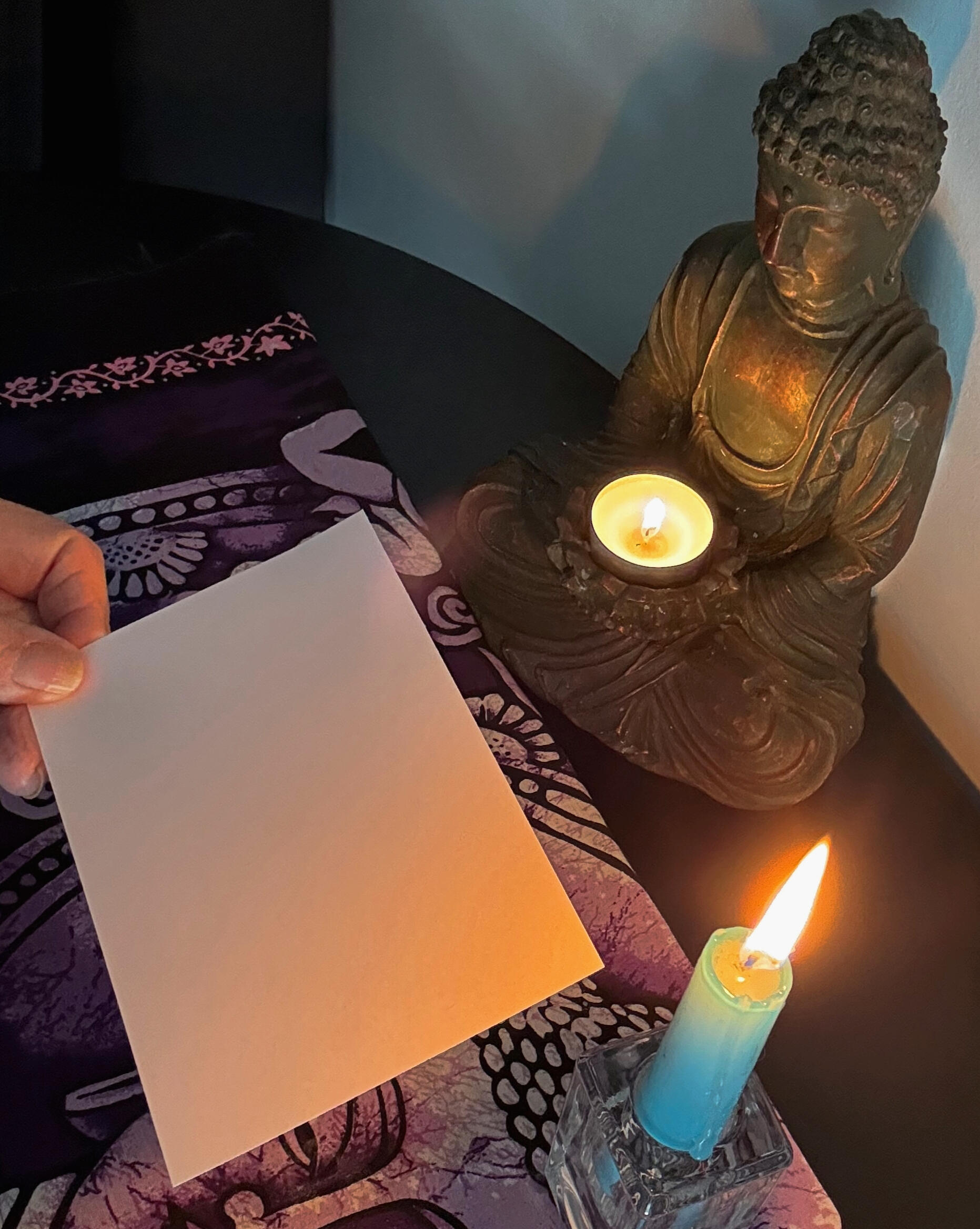 A blank Bristol card held near a candle flame during Diane Stackwick's soot art process.