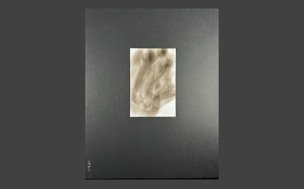 A blank Bristol card held near a candle flame during Diane Stackwick's soot art process.
